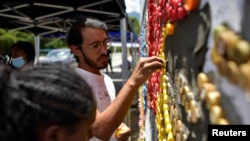 L'artiste vénézuélien Oscar Olivares utilise des capsules de bouteilles pour créer une fresque écologique colorée afin de sensibiliser au recyclage, à Caracas, Venezuela, le 19 août 2022. REUTERS/Gaby Oraa