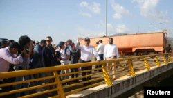 Le ministre colombien des Transports, Guillermo Reyes González, salue lors d'une visite du pont international de Tienditas à la frontière entre la Colombie et le Venezuela après une réunion d'hommes d'affaires colombiens et vénézuéliens, dans le cadre de