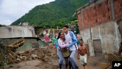 Une femme pleure alors qu'elle cherche un parent disparu dans une zone inondée à Las Tejerias, au Venezuela, le dimanche 9 octobre 2022. Des jours de fortes pluies ont provoqué des crues soudaines et fait déborder une rivière.  (AP Photo/Matias Delacroix)