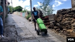 Wilmer Escobar, 50 ans, pousse une brouette chargée de chars lourds dans une ruelle escarpée de La Guaira, au Venezuela.