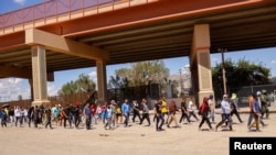 Des migrants, principalement du Venezuela, marchent après avoir été détenus par des agents de la US Border Patrol après être entrés aux États-Unis depuis le Mexique pour se rendre pour demander l'asile, à El Paso, Texas, États-Unis, le 14 septembre 2022. REUTERS/José Luis González
