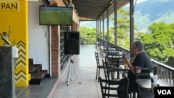 Un homme regarde un match de football de la Coupe du monde dans une boulangerie de Caracas, au Venezuela, le lundi 21 novembre 2022.