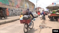 Après le shopping, Daniel Córdoba emballe soigneusement ses courses dans un panier improvisé sur son vélo. [Foto: Federico Buelvas]