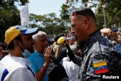 Un membre de la police nationale bolivarienne s'adresse aux fonctionnaires lors d'une manifestation réclamant de meilleurs salaires dans un contexte d'inflation, à Caracas, au Venezuela, le 16 janvier 2023.
