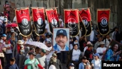 Les partisans portent des bannières du Front sandiniste de libération nationale (FSLN) et un portrait du président Daniel Ortega, alors qu'ils participent à une marche pro-gouvernementale à Managua, au Nicaragua, le 11 février 2023. REUTERS/Stringer