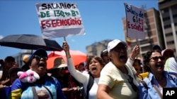 Des fonctionnaires manifestent pour obtenir de meilleurs salaires et avantages sociaux devant le ministère de l'Éducation à Caracas, au Venezuela, le lundi 27 mars 2023. (AP Photo/Ariana Cubillos)