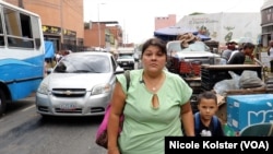 Virmania Cáceres se promène dans un marché populaire de Caracas avec neuf dollars en poche, qu'elle reçoit pour 15 jours de travail en tant qu'enseignante.