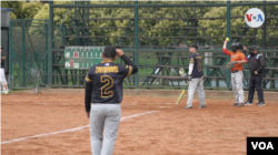 Une image avec un groupe de joueurs de softball vénézuéliens qui pourrait avoir lieu n'importe où au Venezuela, mais qui se déroule à des milliers de kilomètres, à Bogotá, où ce sport a pris de l'ampleur.  Photo : Israël Navas, VOA.