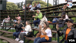 Les membres de la famille des joueurs de softball en profitent pour se faire des amis et encourager leurs proches depuis les gradins.  Photo : Israël Navas, VOA.