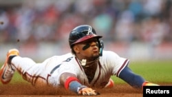 Le joueur de baseball vénézuélien Ronald Acuña Jr. se glisse au troisième but lors d'un match contre les Mets de New York début mai.
