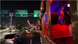 Une femme sort son corps de l'une des fenêtres du bus coloré, qui imite les chèvres de Colombie, du Costa Rica, de l'Équateur et du Panama.