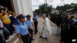 Le père Edwin Román retourne à son église après avoir échoué à convaincre la police d'autoriser les proches des manifestants antigouvernementaux morts et emprisonnés à entrer dans l'église San Miguel Arcángel à Masaya, au Nicaragua, le jeudi 14 novembre 2019. (Photo AP/Alfredo Zúñiga)
