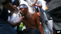 DOSSIER – Un manifestant blessé reçoit les premiers soins après avoir été abattu par un fusil de chasse lors d'affrontements avec la police, alors qu'il manifestait contre le président nicaraguayen Daniel Ortega, à Managua, au Nicaragua, en mai 2018.