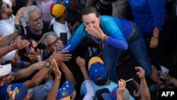 La chef de l'opposition vénézuélienne María Corina Machado salue ses partisans lors d'une manifestation à Valence, dans l'État de Carabobo, au Venezuela, le 13 mars 2024.