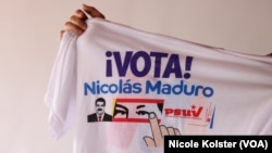Sandoval tient un t-shirt avec de la propagande en faveur de Maduro, qui veut se projeter jusqu'à 18 ans au pouvoir