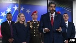 Le président Nicolás Maduro témoigne devant la presse, accompagné de son épouse Cilia Flores, de chefs militaires et de gardes du corps, au siège de la Cour suprême de justice de Caracas, le 2 août 2024.