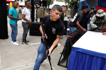 Un jeune homme tient une arme