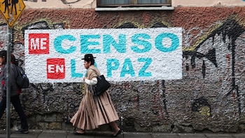Une femme Aimara marche devant