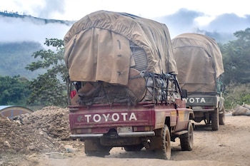 Deux camions transportent des barils de