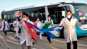 Des médecins cubains brandissent des drapeaux cubains