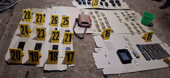 Objets saisis au sol : des munitions, des radios, des smartphones, un sac en cuir et des marqueurs de preuves numérotés