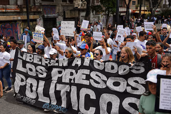 Les membres des familles des détenus, ainsi que des militants et des étudiants, participent à une marche silencieuse pour dénoncer les récents décès en détention par l'État et appeler à la libération de leurs proches, à Caracas, au Venezuela, le 20 mai 2026. La bannière indique "Libérer tous les prisonniers politiques". REUTERS/Gaby Oraa