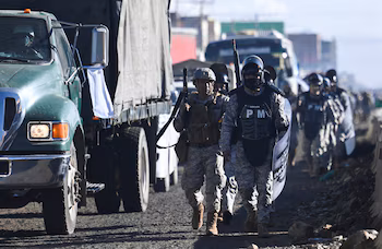 Des policiers militaires marchent en essayant d'ouvrir "couloirs humanitaires" dans le cadre de manifestations à l'échelle nationale visant à faire pression sur le gouvernement du président bolivien Rodrigo Paz pour qu'il renverse les mesures d'austérité et s'attaque à la hausse du coût de la vie, à El Alto, en Bolivie, le 23 mai 2026. REUTERS/Claudia Morales