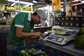PHOTO DE DOSSIER – Un vendeur utilise un appareil de point de vente (POS) sur un stand d'un marché municipal de Caracas, Venezuela, le 10 février 2023. REUTERS/Gaby Oraa