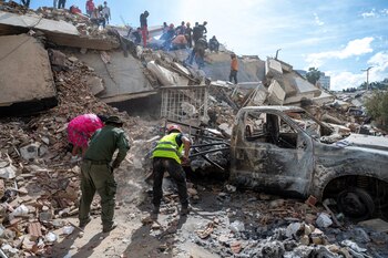 Des sauveteurs et des volontaires travaillent parmi les décombres d'un bâtiment effondré dans l'État de La Guaira, au Venezuela, à la recherche de survivants après les tremblements de terre (REUTERS)