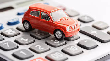 Concept de coûts dans l'industrie automobile, avec un véhicule miniature sur une calculatrice et de l'argent, représentant la planification financière et l'impact économique dans le secteur automobile. (Image d’illustration Infobae)