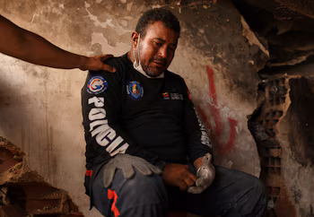 Jimmy Gamboa est réconforté par un ami tandis que les sauveteurs recherchent les corps de sa femme et de son fils de 16 ans à La Guaira, une douleur que MSF tente d'accompagner par un soutien psychologique (Photo : REUTERS/Pablo Sanhueza).