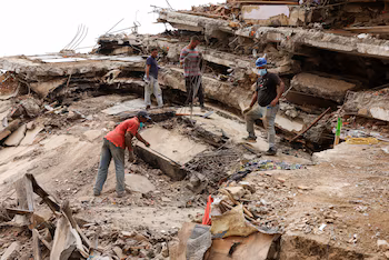 Des gens travaillent ensemble pour rechercher leurs proches dans les décombres, après les tremblements de terre du 24 juin, à Caraballeda, La Guaira, Venezuela, le 19 juillet 2026 (REUTERS/Gaby Oraa)