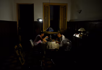 Mayra Madariaga, 72 ans, et Renato Lombard, 74 ans, un couple de retraités dont les trois enfants vivent aux États-Unis, dînent chez eux à la lumière des lanternes lors d'une panne d'électricité à La Havane, Cuba, le 2 septembre 2025. Cuba a demandé le soutien du Programme alimentaire mondial des Nations Unies pour garantir l'approvisionnement alimentaire des groupes vulnérables. REUTERS/Norlys Pérez.