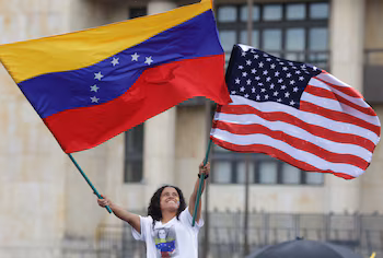 Un Vénézuélien brandit un drapeau vénézuélien et un drapeau américain sur la Plaza de Bolívar pour célébrer après que le président américain Donald Trump a annoncé que les États-Unis avaient mené une action militaire au Venezuela et capturé le dictateur Nicolás Maduro et son épouse Cilia Flores. REUTERS/Andrés Galeano