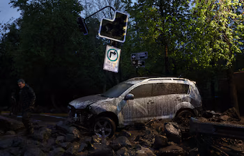 Une voiture endommagée repose parmi les décombres d'une rue après que de fortes pluies ont provoqué un glissement de terrain à Santiago, au Chili, le 8 octobre 2026 (REUTERS/Pablo Sanhueza)