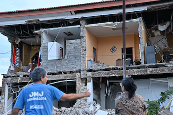 Un couple observe les dégâts causés à un bâtiment touché après le tremblement de terre qui a secoué la côte Pacifique du Panama (Photo de MARTIN BERNETTI / AFP).
